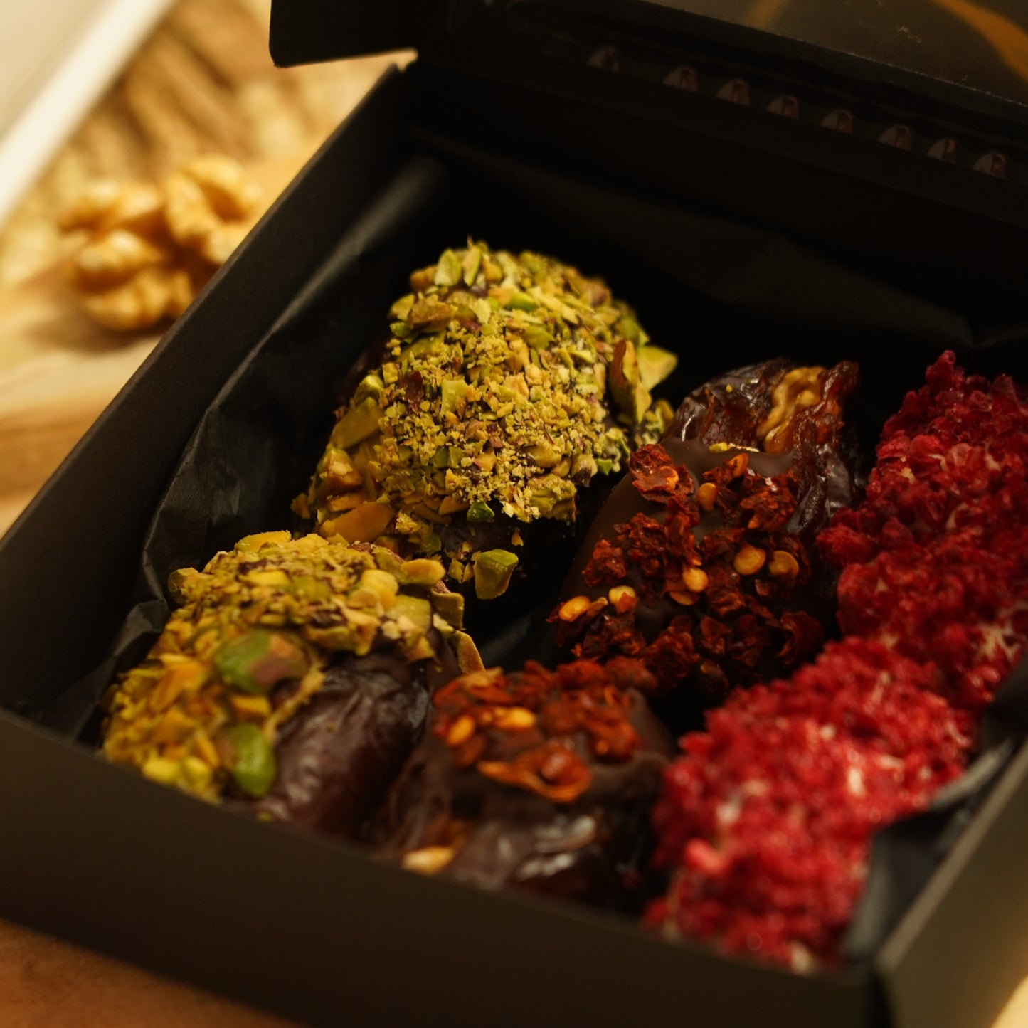 bliskie ujęcie pistacji chilli i malin na daktylach